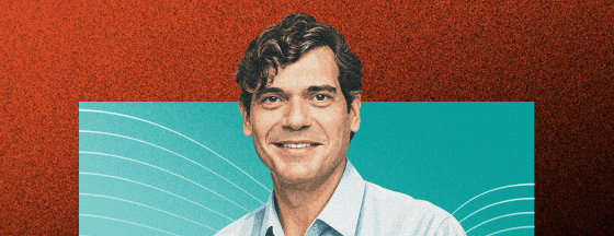 Smiling man in a light blue shirt against a teal background with curved white lines and a textured orange border.